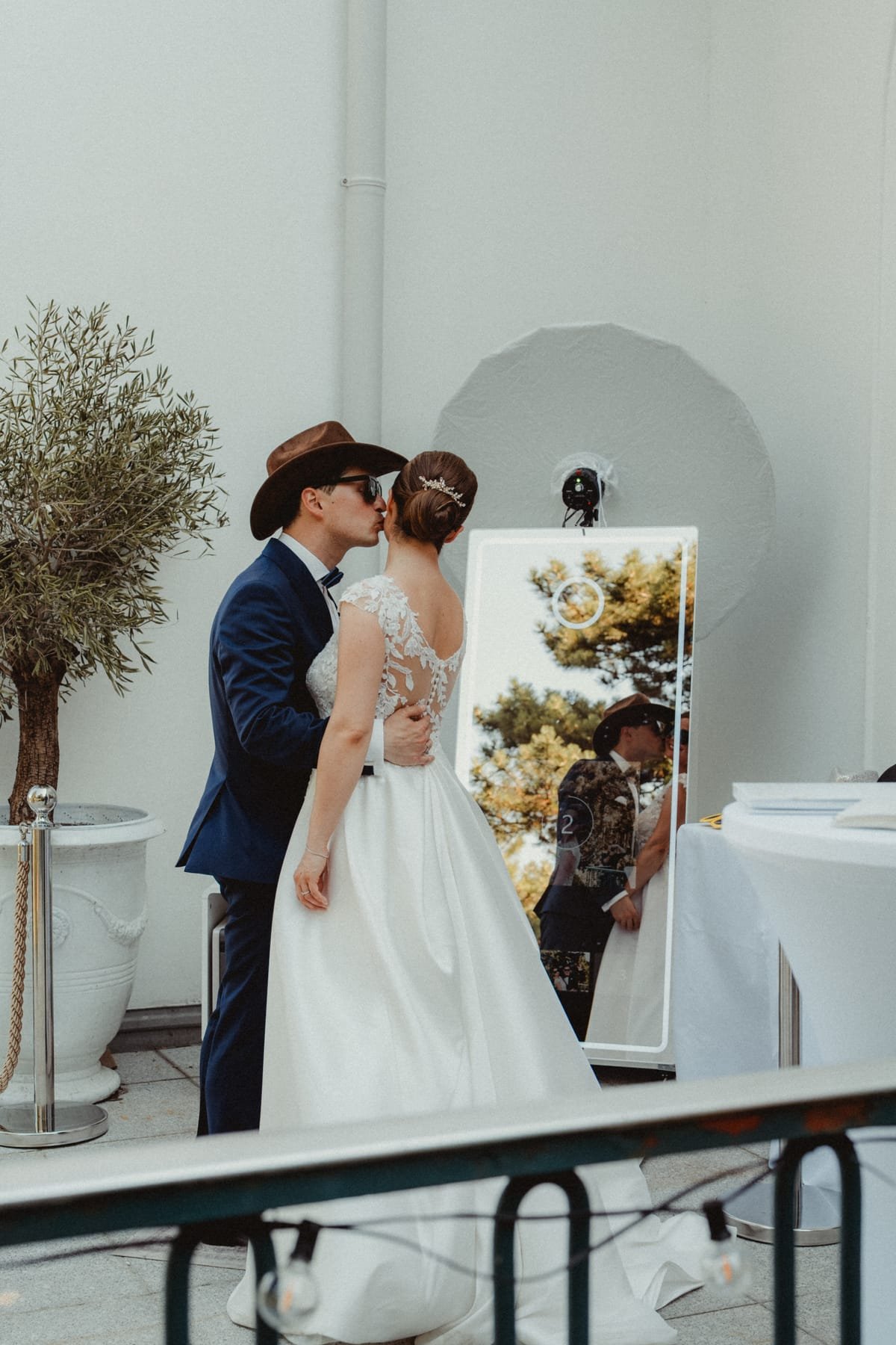 Brautpaar küsst sich vor dem evibox Magic Mirror bei ihrer Hochzeit im Freien